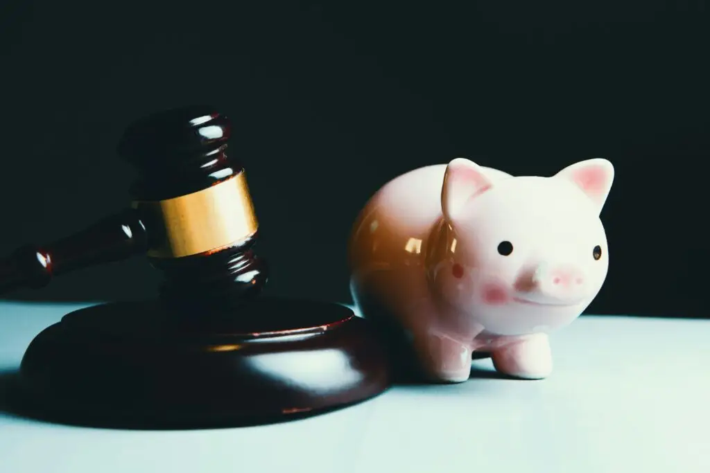 Gavel beside a pink piggy bank