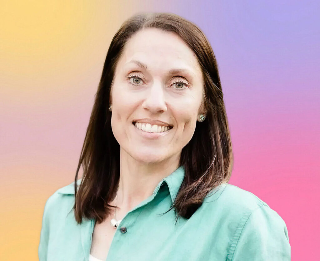 Katherine M. Brennan, a woman with straight brown hair and blue eyes, smiles at the camera in a green collared shirt. The background features a soft gradient of yellow, purple, pink, and blue.
