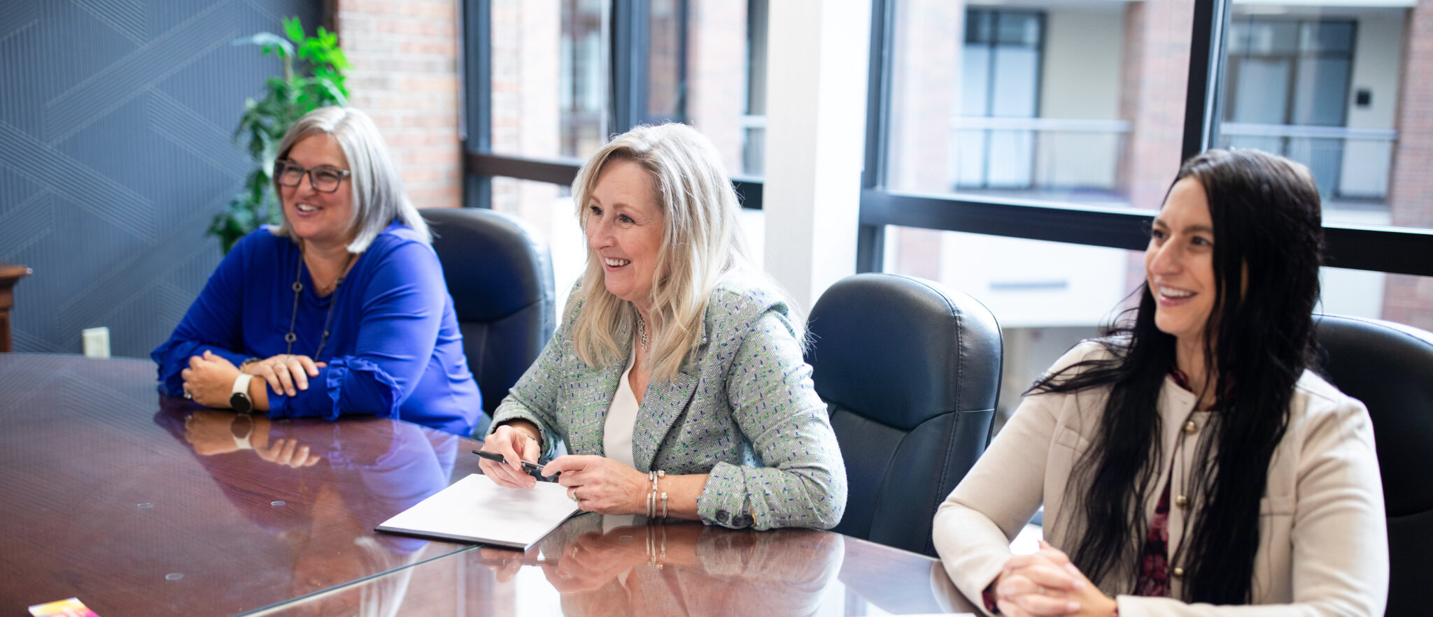 Three Everbright Legacy Law team members smile and talk at the conference table in the Richfield office