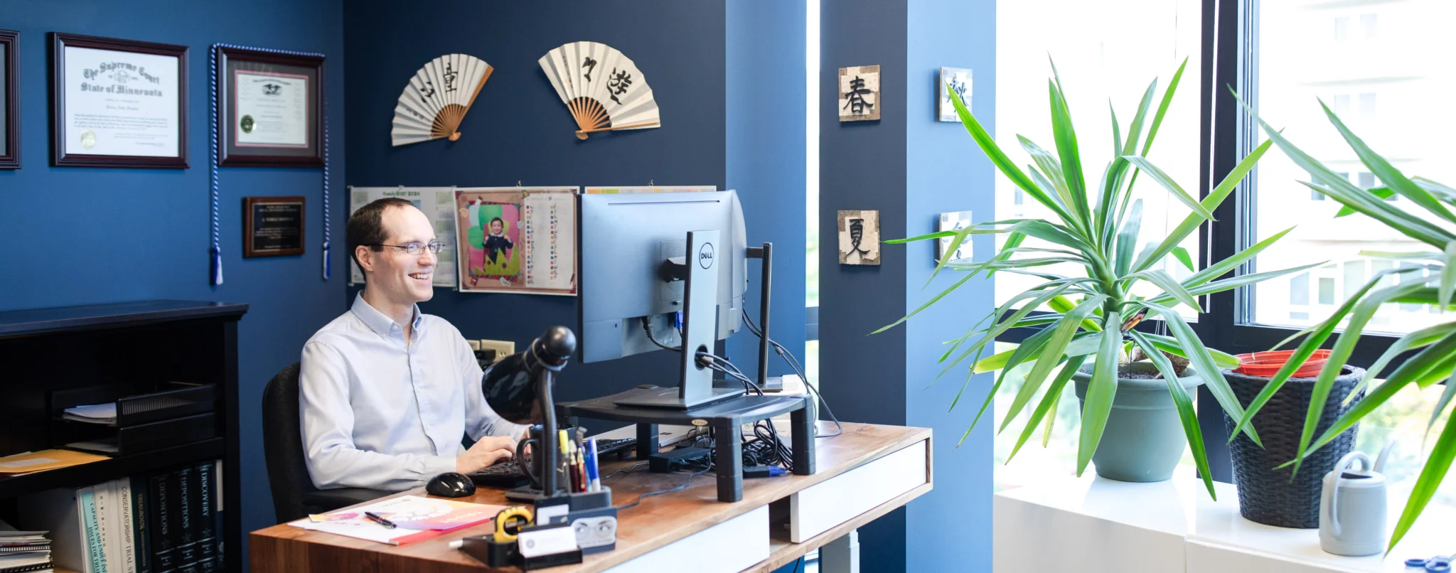 Noble Simpson, Partner, Attorney at Law, smiling at his desk